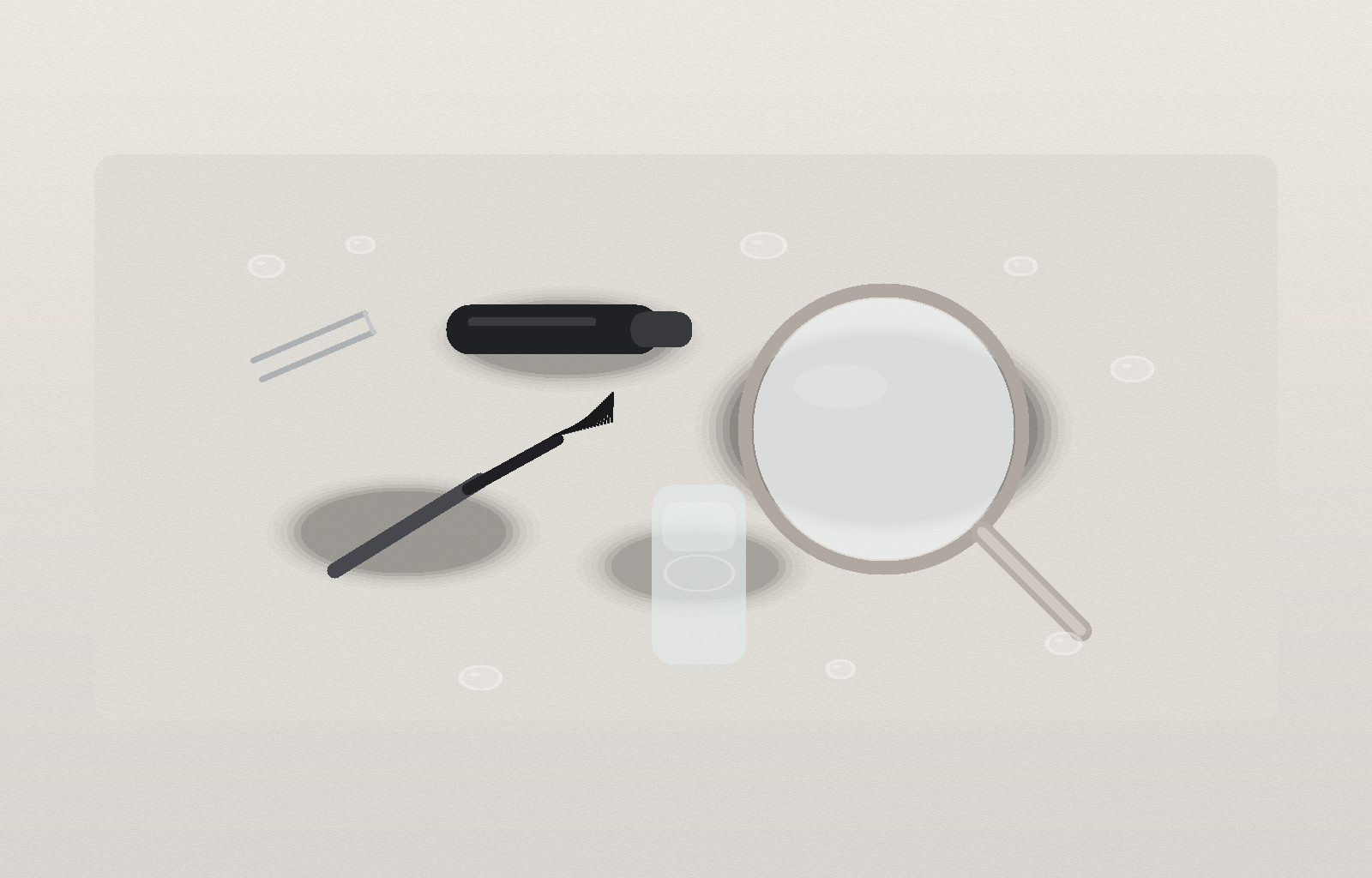 Still life of a black mascara tube and wand, silver tweezers, a small clear gel tube, a round hand mirror, and water droplets on a pale stone surface.