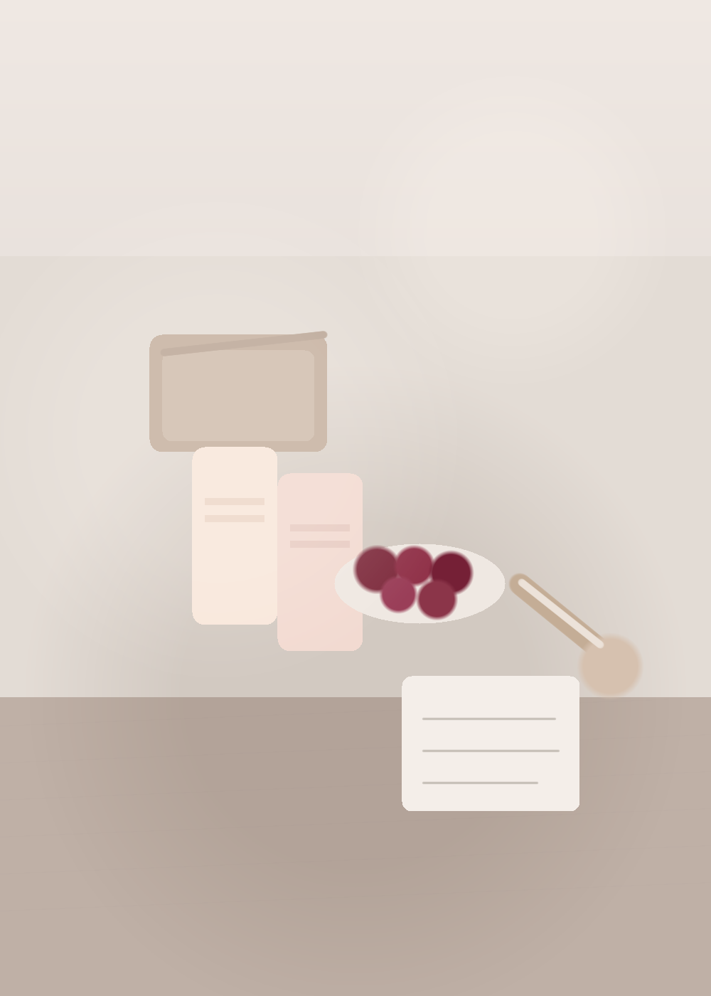 An editorial still life of opened collagen jelly pouches, a glass bowl of berries, a spoon, and a notebook on a stone countertop in soft afternoon light.