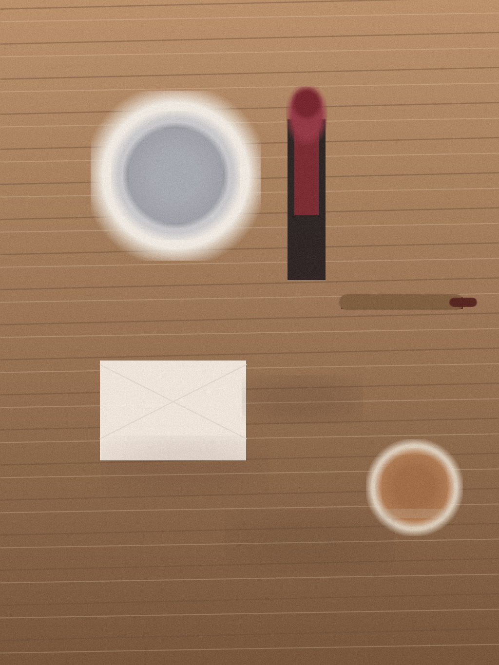 Close still life of an oxblood lipstick, lip liner, compact mirror, tissue, and tea glass on a small wooden vanity.