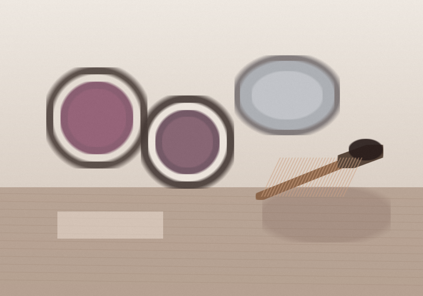 Open pots of plum and mauve eye color sit on a stone vanity beside a brush and a small mirror in soft window light.