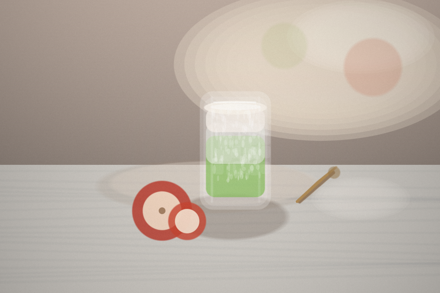 An editorial still life of an iced apple-cinnamon matcha latte on a marble cafe table beside a sliced red apple and a bamboo whisk in soft afternoon light.