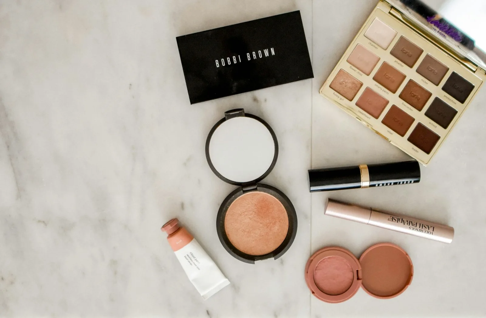 Makeup and brushes arranged on a table